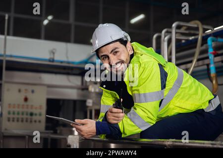 Porträt zufriedener Ingenieur Fabrikarbeiter Vorarbeiter Vorarbeiter in der Schwerindustrie sitzen entspannen sich und lächeln in der Kamera. Stockfoto
