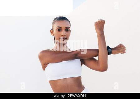 Junge muskulöse Frau, die draußen ihre Hände wärmt Stockfoto