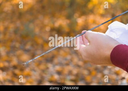 Ein Mann überprüft den Ölstand im Automotor. Selbstbedienung des Autos. Regelmäßige Überprüfung des Ölstands im Motor. Stockfoto