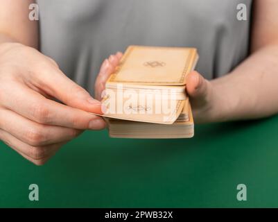 Hände mit Tarotkarten, die Karten werden in zwei Teile geteilt, um sie zu enthüllen, Taro zum Lesen auswählen, die Zukunft bestimmen. Stockfoto