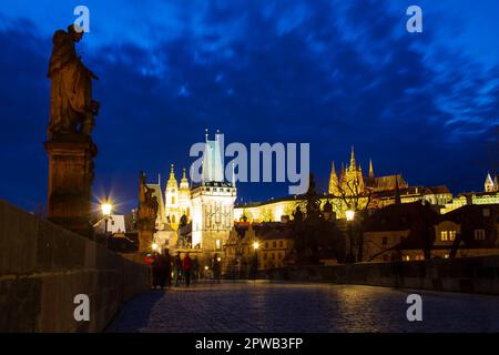 Karlsbrücke vor der Tür und die Kathedrale hinten bei Nacht in Prag. Stockfoto