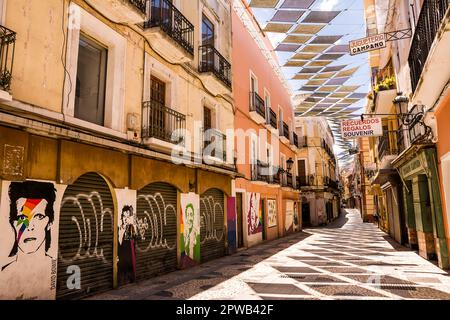 Badajoz, Spanien - 24. Juni 2022: Gasse mit bunten Markisen und Wandgemälden im Zentrum von Badajoz Stockfoto