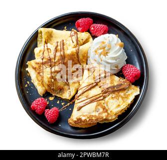 Teller mit frisch gebackenen Crepes mit Schlagsahne und Himbeeren isoliert auf weißem Hintergrund, Draufsicht Stockfoto