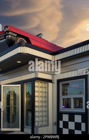 Burgerrestaurant im Vintage 60s- oder 50s-Stil mit einem 1963 Cadillac Cabrio auf dem Dach. Angel's Drive-in, Calgary, Alberta, Kanada Stockfoto