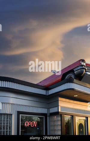 Burgerrestaurant im Vintage 60s- oder 50s-Stil mit einem 1963 Cadillac Cabrio auf dem Dach. Angel's Drive-in, Calgary, Alberta, Kanada Stockfoto