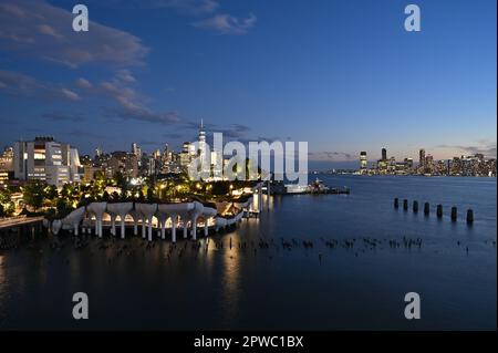 Little Island und der Hudson River in der Abenddämmerung vom Pier 57 Rooftop Park, mit Downtown Manhattan und Jersey City im Hintergrund. Manhattan, New York. Stockfoto