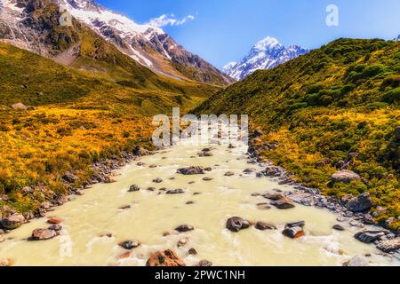 Der Bergbach am Tasman River im Mt Cook-Nationalpark auf der Hooker-Talstrecke von der Hängebrücke bis zum schneebedeckten Berggipfel. Stockfoto