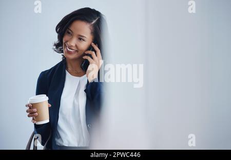 Sie ist immer bereit, Kunden zu helfen, wenn sie anrufen. Eine junge Geschäftsfrau, die mit einem Handy in einem Büro spricht. Stockfoto