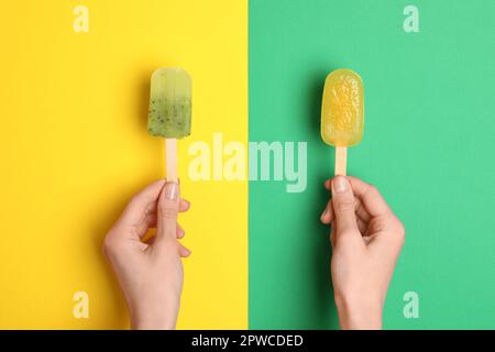 Frau mit köstlichen Eiswürfeln auf farbigem Hintergrund, Draufsicht. Obst-Eis-Eis-Eis Stockfoto