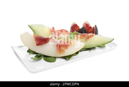 Teller mit leckerer Melone, Jamon, Feigen und Spinat, isoliert auf Weiß Stockfoto