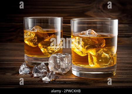 Zwei Gläser mit Eis und Whiskey auf Holzhintergrund Stockfoto