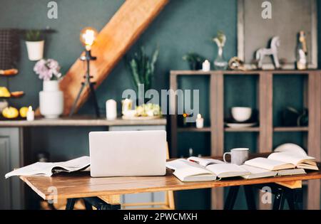 Öffnen Sie das Lehrbuch mit Stift, Laptop, Stapel unbedeckter Bücher, die aufeinander liegen, eine Tasse Kaffee auf einem Holztisch im Wohnzimmerhintergrund. Stockfoto