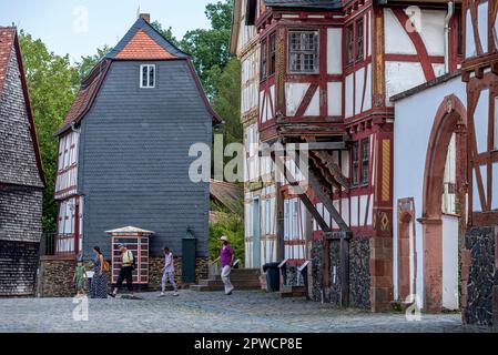 Menschen in einer Straße mit historischen Fachwerkhäusern, im Hinterhaus von Idstein mit Schieferschindeln, Hessenpark Open-Air Museum Stockfoto