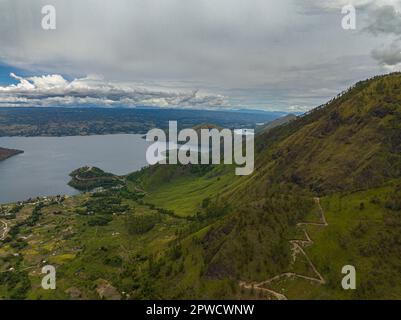 Luftdrohne aus Bergen mit Wald und Toba-See. Die Insel Samosir. Sumatra, Indonesien. Stockfoto