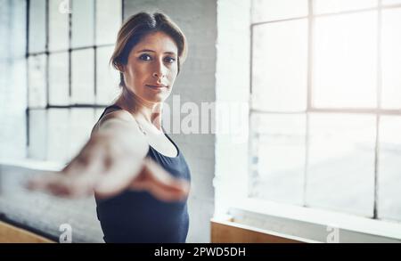 Yoga ist mein Geheimnis. Porträt einer attraktiven jungen Frau, die zu Hause Yoga praktiziert. Stockfoto