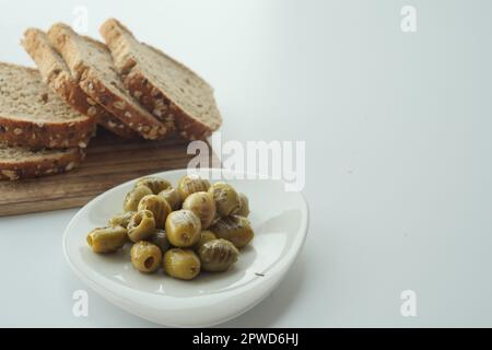 Brot und türkisch gegrillte Oliven auf weißem Hintergrund Stockfoto