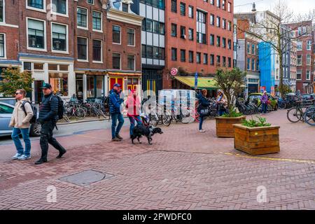 AMSTERDAM, HOLLAND - 17. APRIL 2023: Straßenblick auf Amsterdam, die pulsierende niederländische Hauptstadt, bekannt für ihr Kanalsystem, die engen Häuser und das Radfahren Stockfoto