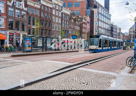 AMSTERDAM, HOLLAND - 17. APRIL 2023: Straßenblick auf Amsterdam, die pulsierende niederländische Hauptstadt, bekannt für ihr Kanalsystem, die engen Häuser und das Radfahren Stockfoto