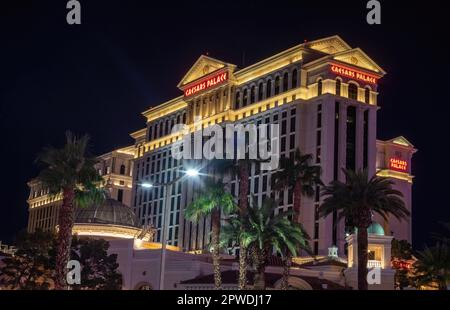 Außenansicht des Caesars Palace Resort and Casino mit Palmen vor der Tür, die bei Nacht auf dem Strip, Las Vegas Blvd., in Las Vegas, Nevada, USA beleuchtet werden. Stockfoto