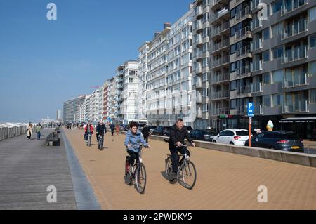 Menschen, die an der Strandpromenade in Ostende, Belgien, entlang der Nordsee Sport treiben und spazieren gehen. Stockfoto