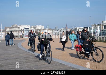 Menschen, die an der Strandpromenade in Ostende, Belgien, entlang der Nordsee Sport treiben und spazieren gehen. Stockfoto