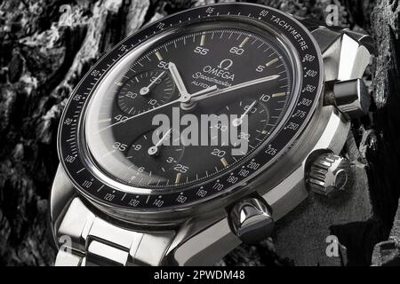 Mailand, Italien - 28. April 2023: Nahaufnahme einer Oldtimer Omega Speedmaster Automatisches luxuriöses Armband, Hintergrund ist eine verschwommene Felsstruktur. Stockfoto