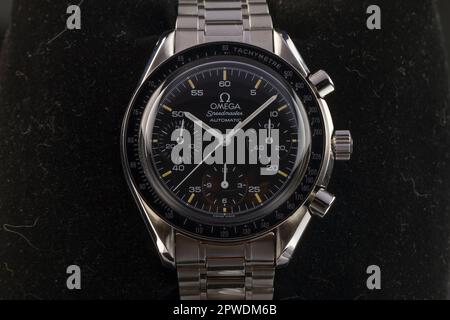 Mailand, Italien - 28. April 2023: Nahaufnahme einer Oldtimer Omega Speedmaster Automatisches luxuriöses Armband, Hintergrund ist eine verschwommene Felsstruktur. Stockfoto