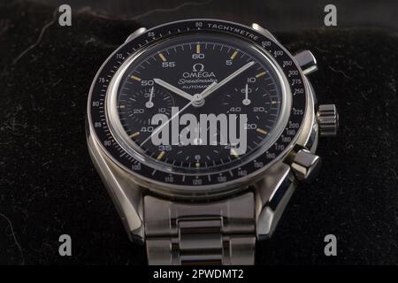 Mailand, Italien - 28. April 2023: Nahaufnahme einer Oldtimer Omega Speedmaster Automatisches luxuriöses Armband, Hintergrund ist eine verschwommene Felsstruktur. Stockfoto