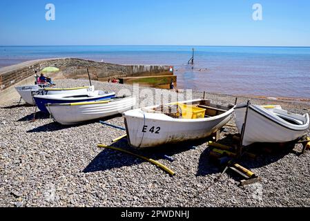 Kleine Fischerboote am Strand mit Blick auf die Küste, Sidmouth, Devon, Großbritannien, Europa. Stockfoto