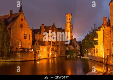 Historisches mittelalterliches Rozenhoedkaai aus dem 13. Jahrhundert, Rosary Quay, Dämmerung, am Dijver-Kanal, UNESCO-Weltkulturerbe mit Belfort-Glockenturm, Brügge Stockfoto