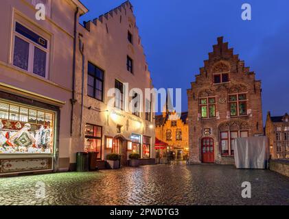 Historische Gebäude, darunter ein Spitzengeschäft in Huidenvettersplein in der Abenddämmerung im Stadtzentrum von Brügge, Belgien, das zum UNESCO-Weltkulturerbe gehört Stockfoto