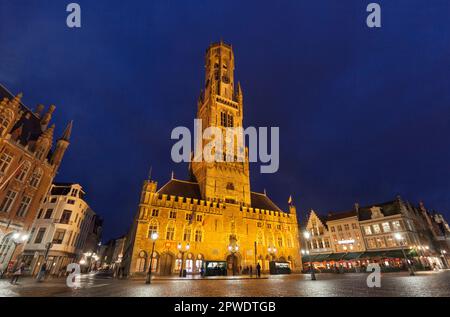 Belfort oder Belfry, mittelalterlicher Glockenturm auf dem Marktplatz Grote Markt aus dem 10. Jahrhundert in der Abenddämmerung im Zentrum des UNESCO-Weltkulturerbes Brügge, Belgien. Stockfoto