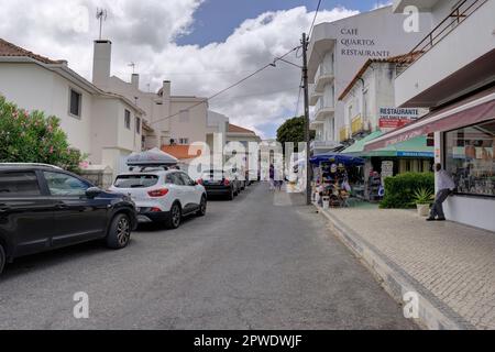 Fatima, Portugal - 15. August 2022: Zufahrtsstraße mit bewegungsunscharfen Fußgängern, Kfz-Restaurants und Geschäften Stockfoto