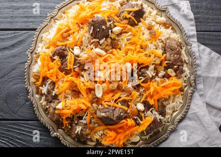 Kabuli pulao luxuriöses afghanisches Pilaf-Gericht auf dem Holztisch. Horizontale Draufsicht von oben Stockfoto