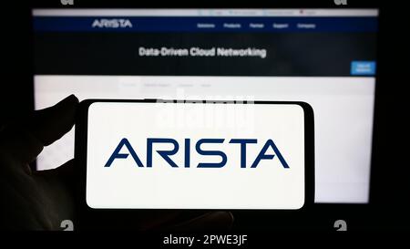 Person, die ein Mobiltelefon mit dem Logo des Computernetzwerkunternehmens Arista Networks Inc. Auf dem Bildschirm vor der Webseite hält. Konzentrieren Sie sich auf das Display des Telefons. Stockfoto