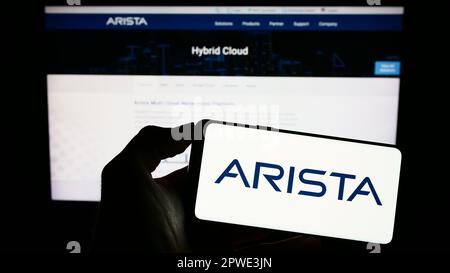 Person, die ein Mobiltelefon mit dem Logo des Computernetzwerkunternehmens Arista Networks Inc. Auf dem Bildschirm vor der Webseite hält. Konzentrieren Sie sich auf das Display des Telefons. Stockfoto