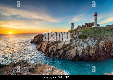 Sonnenuntergang über dem Leuchtturm am Pointe Saint Mathieu in Plougonvelin an der zerklüfteten Küste der Bretagne in Frankreich Stockfoto