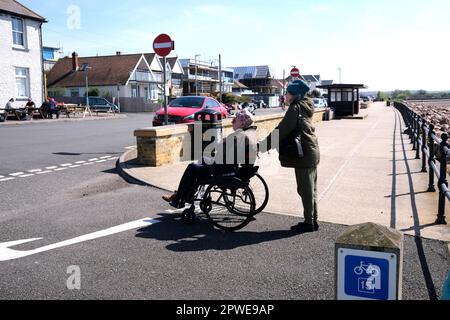 Frau im Rollstuhl mit einer Betreuerin, hampton-on-Sea, Insel thanet, East kent, uk april 2023 Stockfoto