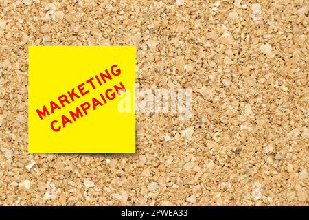 Gelbes Notizpapier mit Word-Marketingkampagne auf Korkbretthintergrund mit Kopierbereich Stockfoto