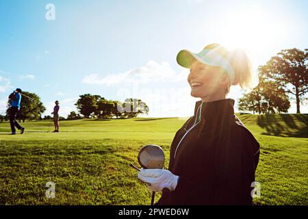 Glück ist eine gemütliche Runde Golf. Eine Frau, die den Tag auf einem Golfplatz verbringt. Stockfoto