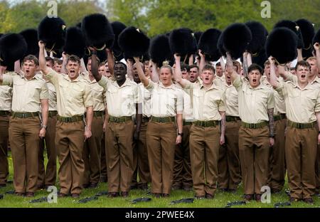 Mitglieder der Waliser Garde ziehen ihr Kopfkleid aus, während sie König Charles III. Dreimal anfeuern, während einer Probe im Tri-Service und Commonwealth bei der RAF Odiham in Hampshire, Vor ihrer Beteiligung an der zweiten Prozession, die König Karl III. Und Königin Camilla von Westminster Abbey zurück zum Buckingham Palace begleitet, nach der Krönungsfeier am 6. Mai in der Abtei in London. Foto: Sonntag, 30. April 2023. Stockfoto