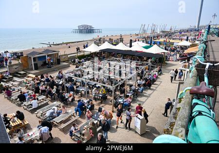 Brighton UK 30. April 2023 - Besucher genießen die warme Sonne am Brighton Beach und am Meer, während die Menschenmassen über das Feiertagswochenende an die Küste strömen : Credit Simon Dack / Alamy Live News Stockfoto