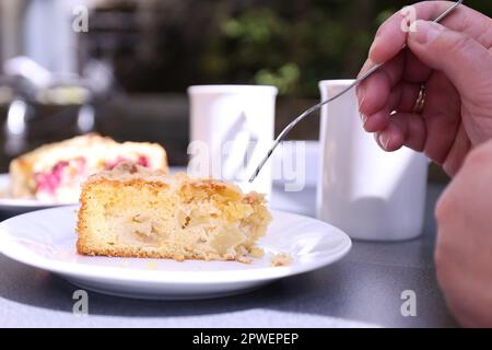 Solingen, Deutschland. 30. April 2023. Die Leute kaufen Kaffee und Kuchen im Solinger botanischen Garten. Die Molitor-Familie (Hände) auf dem Bild ist den ganzen Weg von Wermelskirchen gekommen, um den „Todeskuchen“ zu kaufen. Kredit: David Young/dpa - ACHTUNG: Nur zur redaktionellen Verwendung im Zusammenhang mit der aktuellen Berichterstattung und nur mit vollständiger Erwähnung der oben genannten Credit/dpa/Alamy Live News Stockfoto