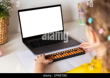 Ein Mädchen von hinten ist in der mentalen Arithmetik auf dem Abakus aktiv, online auf einem Laptop, Chroma Key Hintergrund. Das Konzept, Kindern das beizubringen Stockfoto