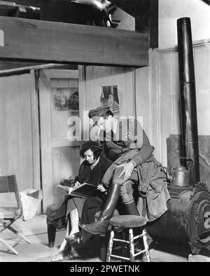 Der US-amerikanische Schauspieler GARY COOPER schaut dem Drehbuchmädchen über die Schulter auf dem Set von TODAY WE LIVE 1933 Regisseur HOWARD HAWKS Kurzgeschichte WILLIAM FAULKNER Musik WILLIAM AXT Metro-Goldwyn-Mayer Stockfoto