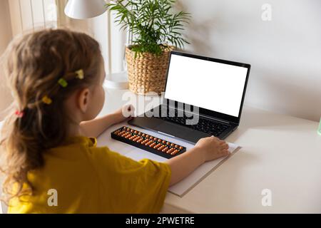 Ein Mädchen von hinten ist in der mentalen Arithmetik auf dem Abakus aktiv, online auf einem Laptop, Chroma Key Hintergrund. Das Konzept, Kindern das beizubringen Stockfoto