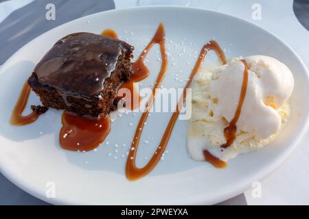 Sticky Toffee Pudding mit warmer Toffee Sauce und Eiscreme wird in den meisten irischen Restaurants serviert Stockfoto