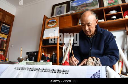 (230430) -- LHASA, 30. April 2023 (Xinhua) -- Gyumey Tsultrim schreibt Sanskrit-Kalligraphie zu Hause in Lhasa, Südwestchina Autonome Region Tibet, 19. April 2023. Im Truzing-Palast von Norbulingka in den westlichen Vororten von Lhasa werden Tausende alter Bücher auf verschiedenen Feldern Tibets in Regalen gelagert. Im Moment besteht die Hauptaufgabe von Gyumey Tsultrim und seinen Kollegen darin, die alten Bücher sowohl manuell als auch digital zu inventarisieren. Gyumey Tsultrim wurde 1967 in Chanang County in Shannan geboren. Im Jahr 1986 waren es Experten der Akademie der Sozialwissenschaften der Autonomen Region Tibet Stockfoto