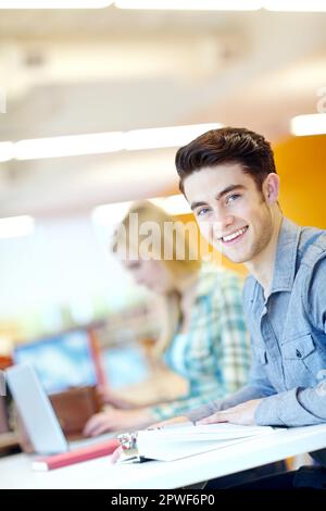 Er ist ein verantwortungsvoller junger Mann. Attraktiver männlicher Student mit seinem Studienkumpel im Hintergrund. Stockfoto