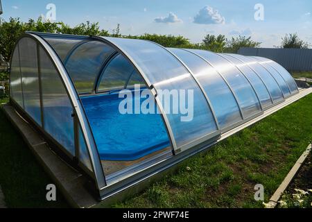 Swimmingpool (im Freien) mit Schiebeabdeckung. Wetterschutz Stockfoto